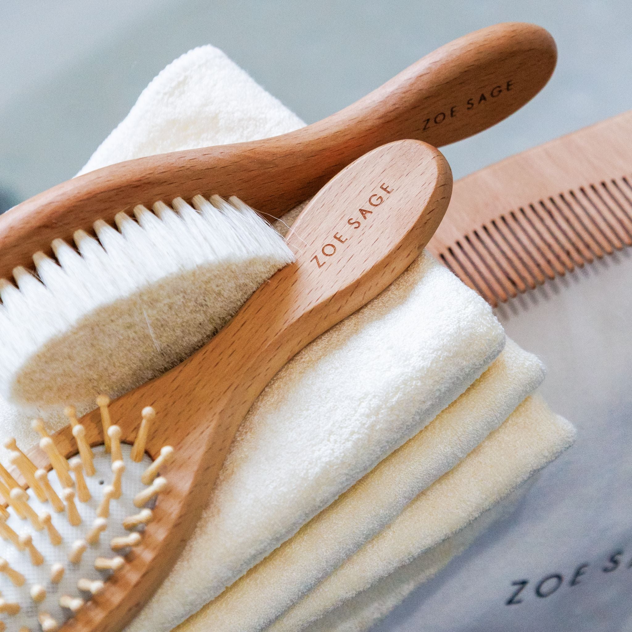 Wooden baby brush and comb set displaying three natural grooming tools.
