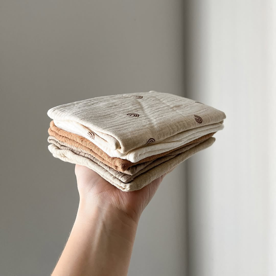 Dusty dunes organic muslin burp cloths arranged in natural light