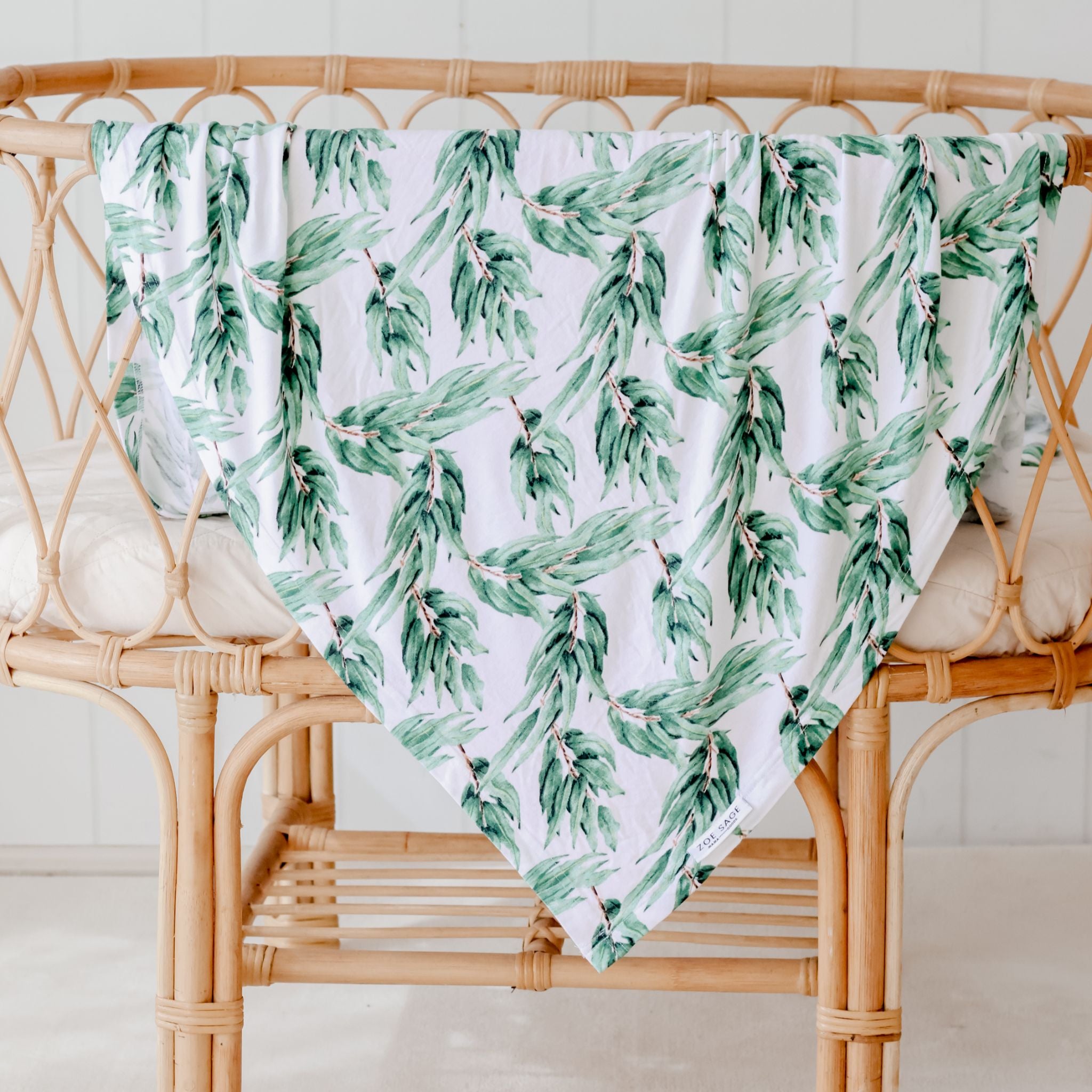 Stretchy baby swaddle wrap in blue gum leaf pattern displayed flat