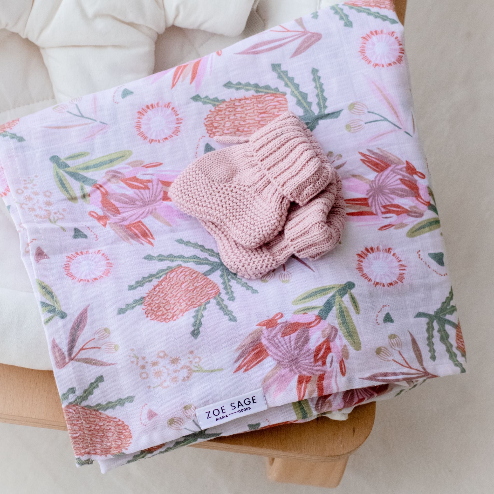 Organic cotton muslin swaddle wrap featuring gumnut blossom print detail.