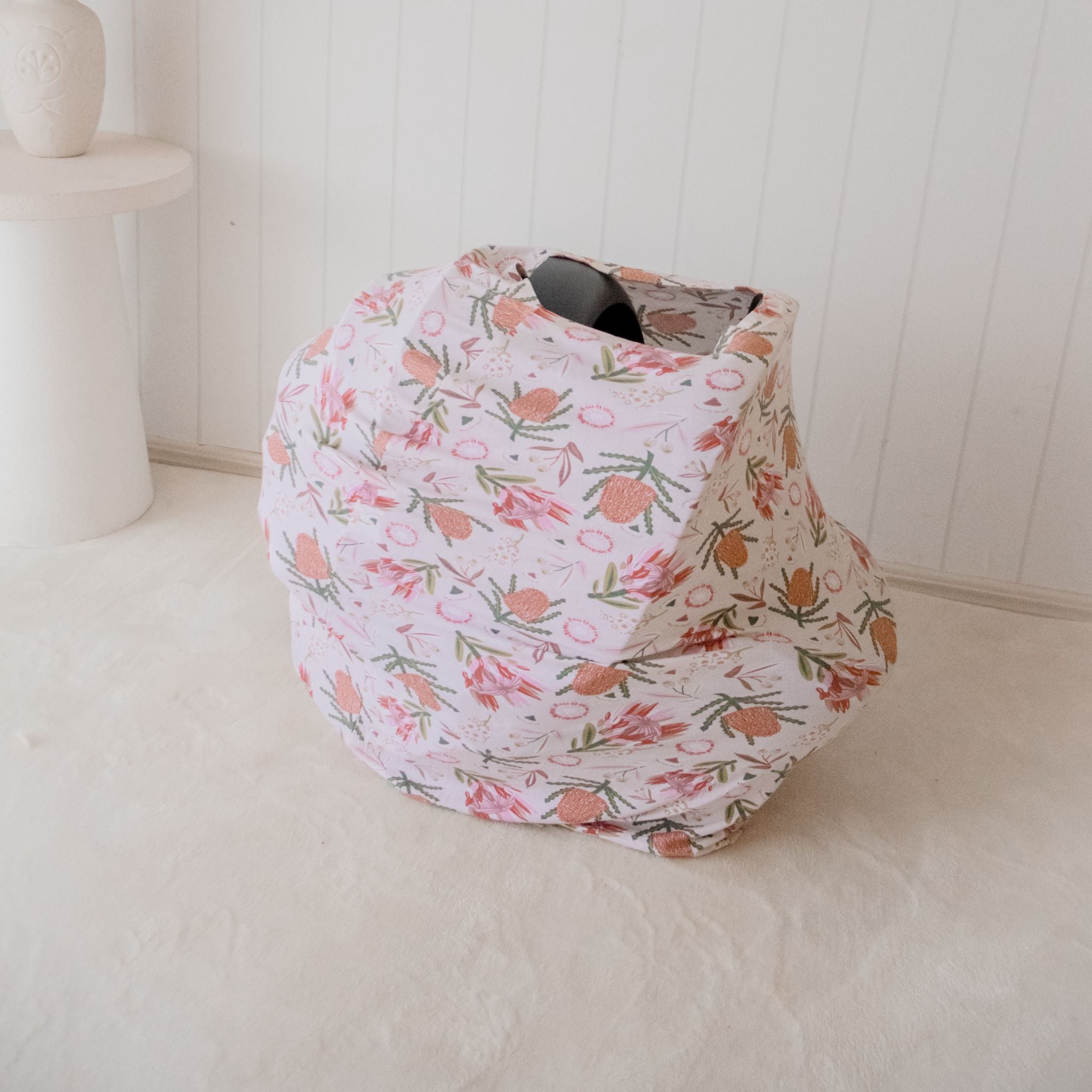 Red gumnut blossom nursing cover draped over shoulder for breastfeeding