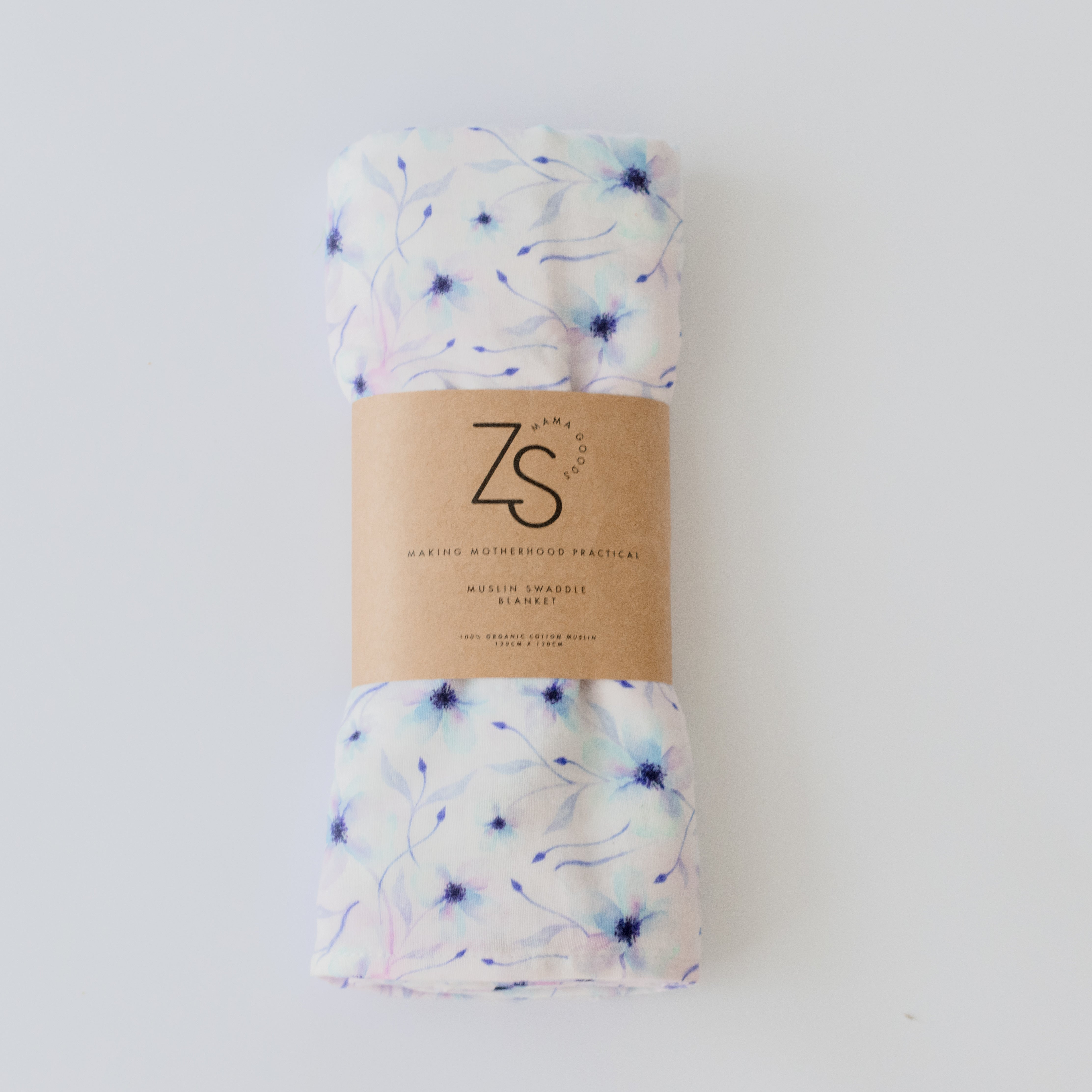Organic cotton muslin swaddle wrap in twilight bloom floral print draped softly.