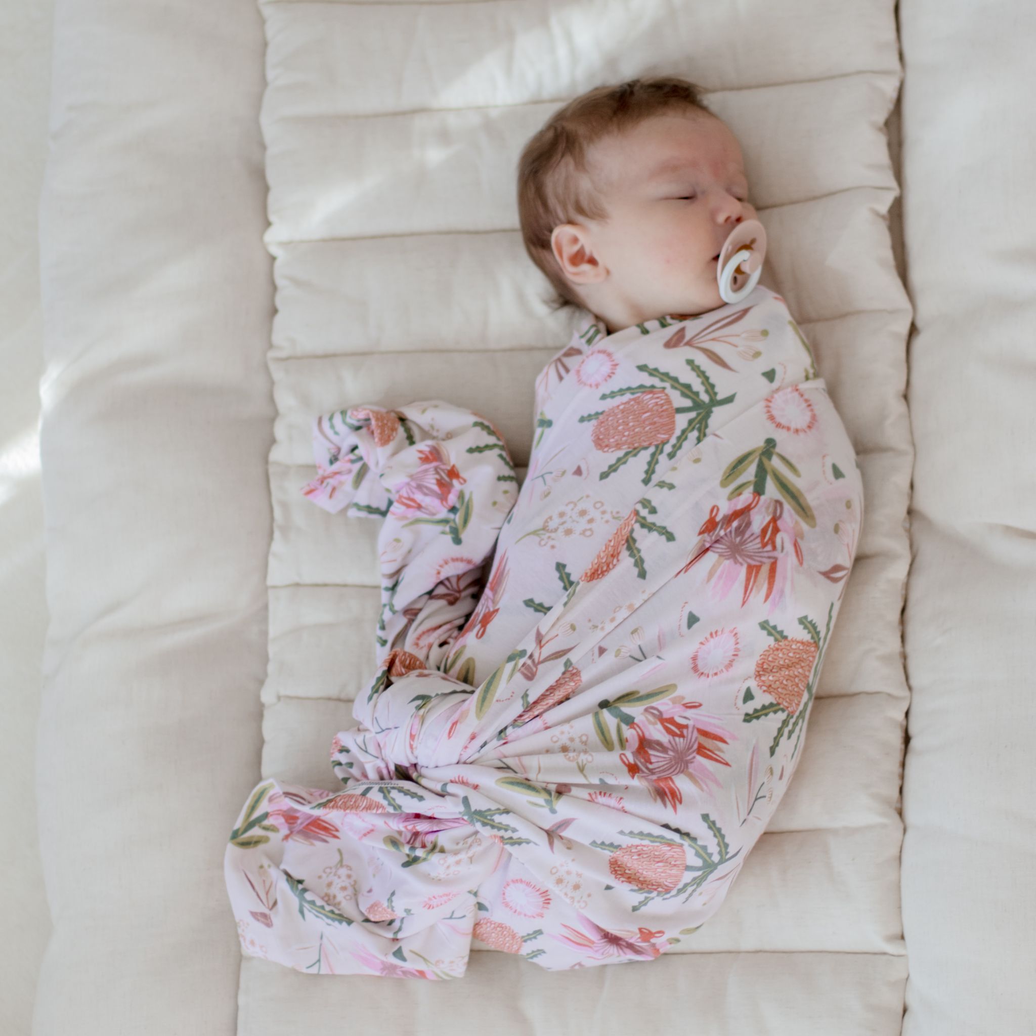 Stretchy gumnut blossom baby swaddle wrap in soft neutral tones by Zoe Sage