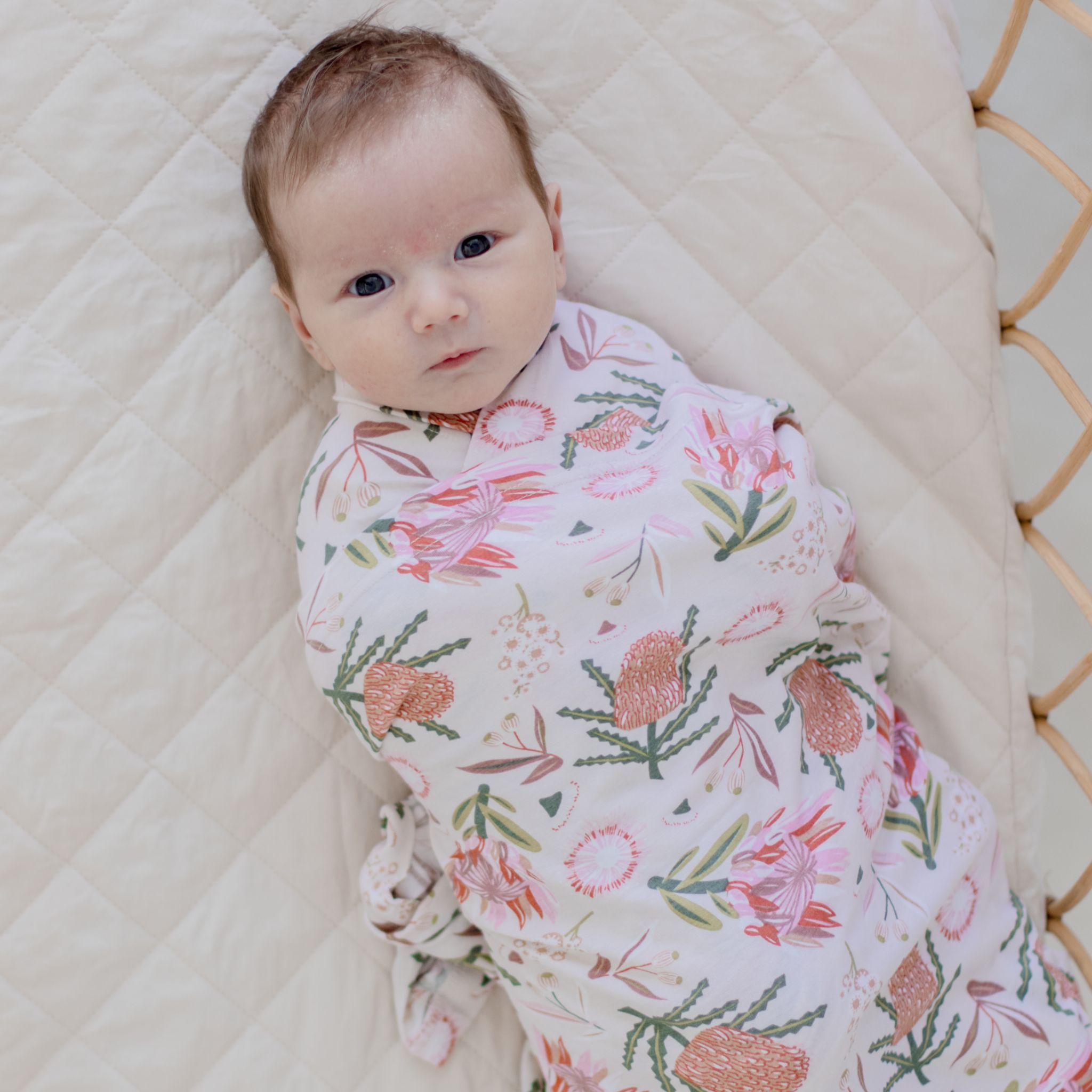 Cream stretchy baby swaddle wrap featuring delicate gumnut blossom print design