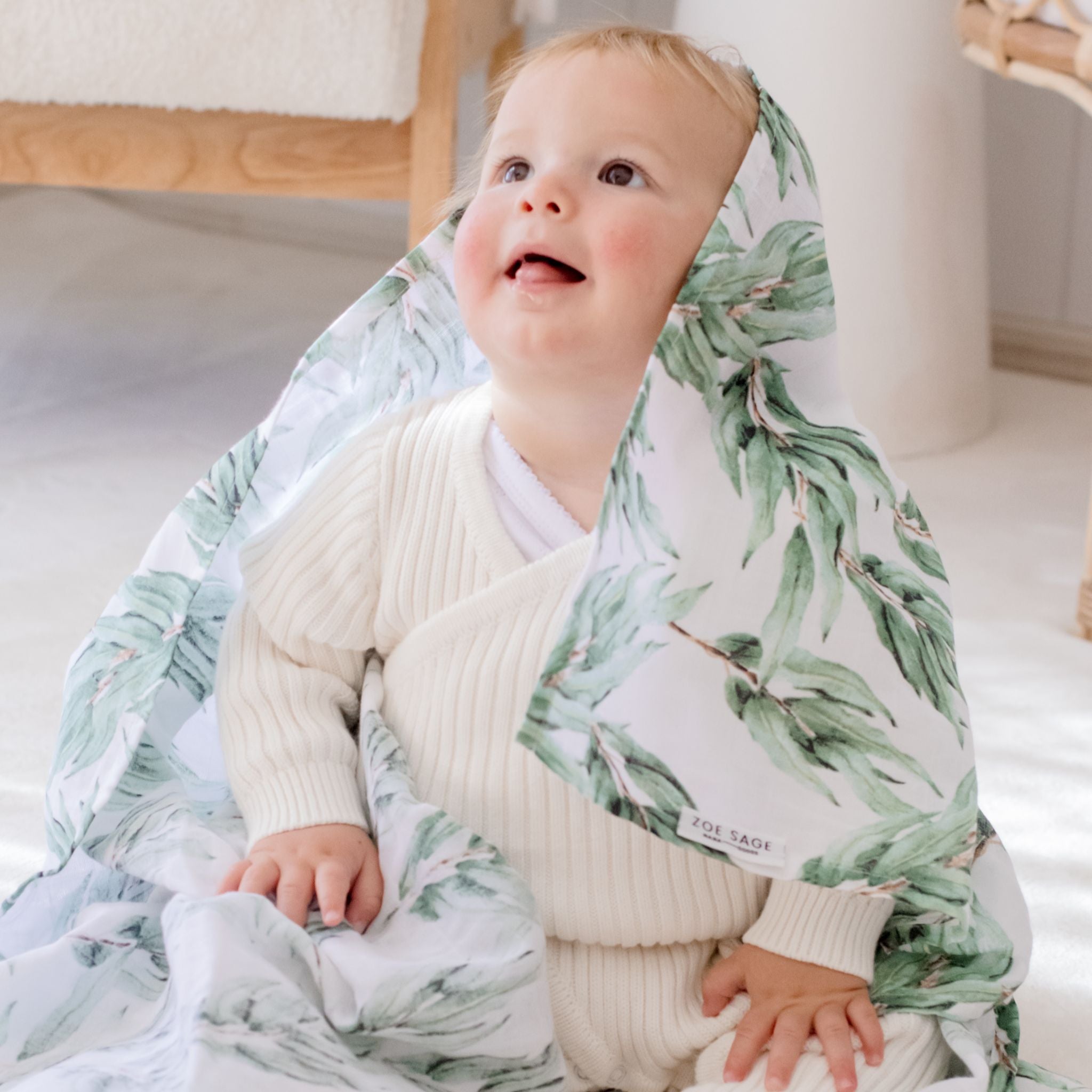 Organic cotton muslin swaddle wrap in blue gum leaf color, packaged for gifting.