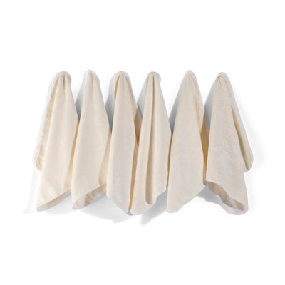 Six white bamboo baby wash cloths rolled together by Zoe Sage
