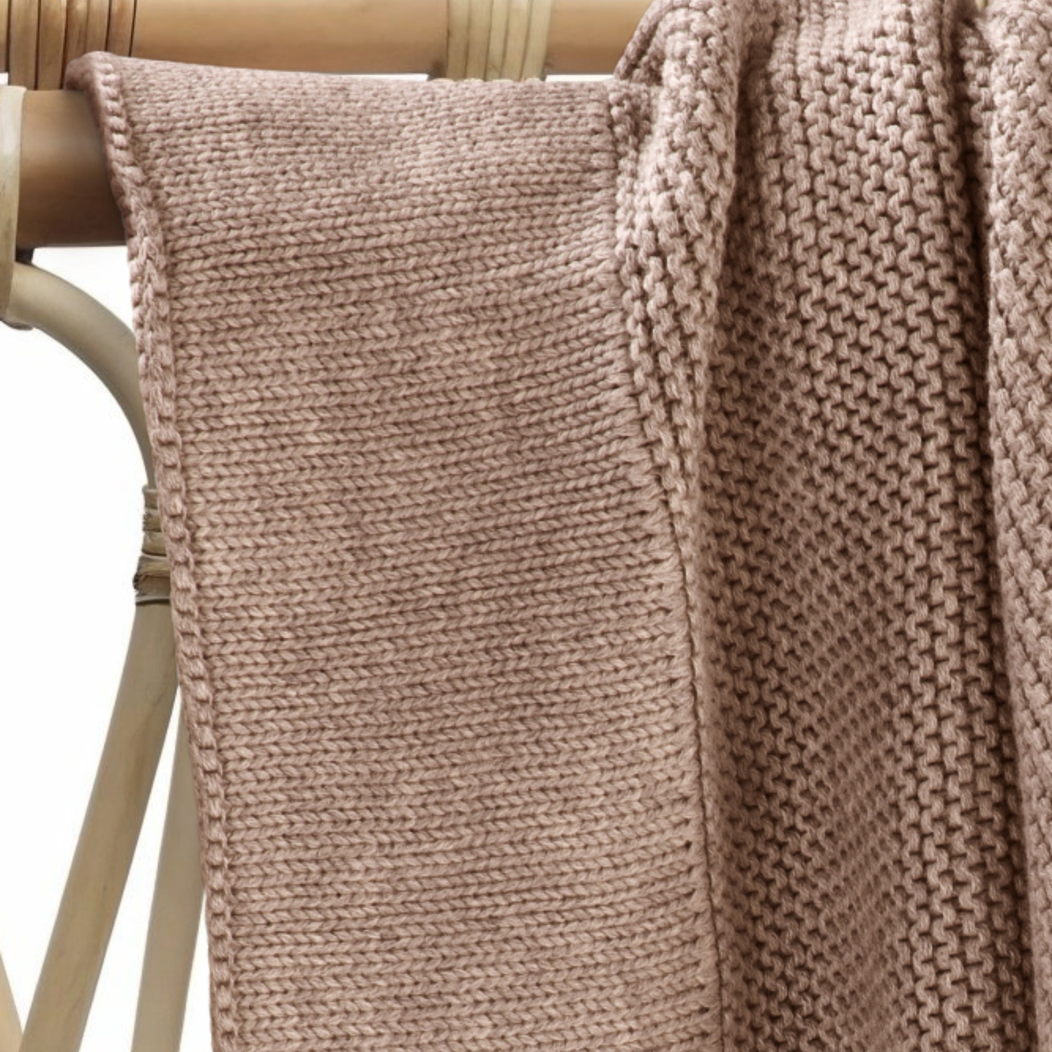 Soft mocha cotton knit baby blanket draped over nursery chair