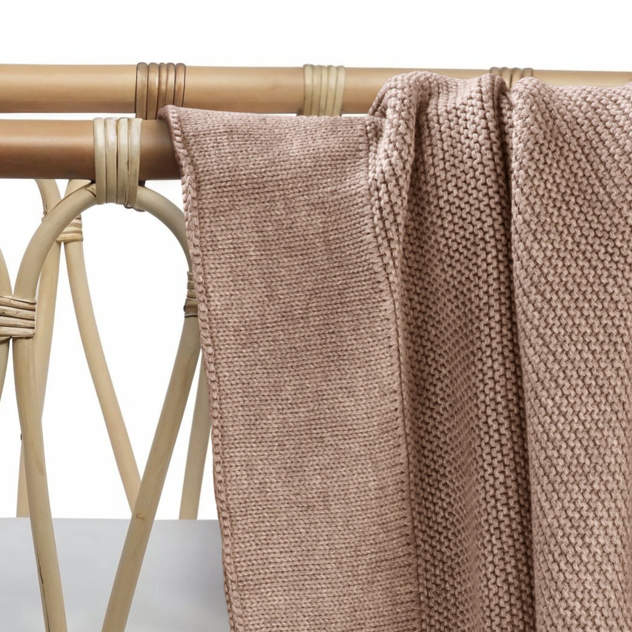 Soft mocha cotton knit baby blanket draped gently on surface