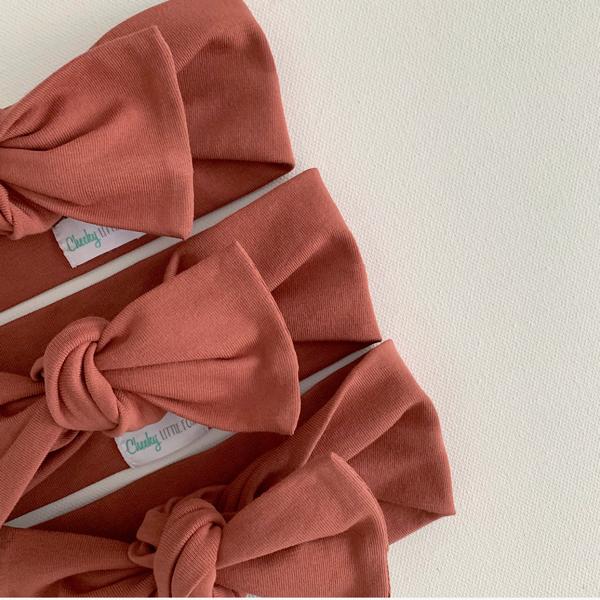 Close up detail of rust colored baby bow knot headband fabric texture