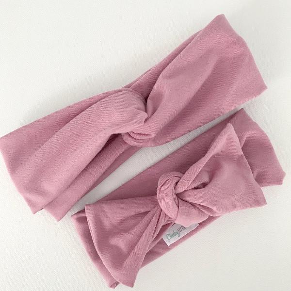 Rose coloured bow knot headband on baby, close up detail view