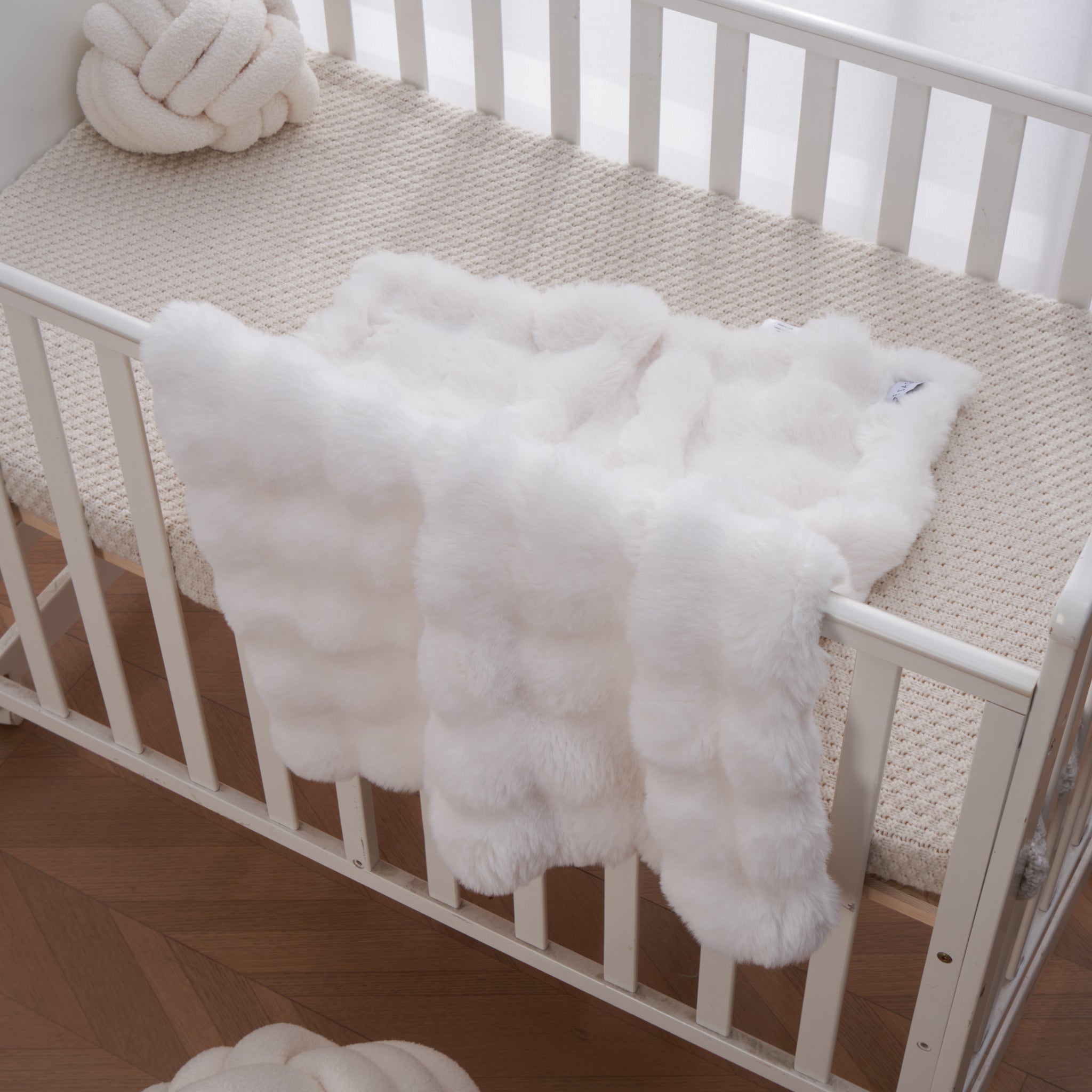 Soft ivory bubble textured baby blanket draped gently over nursery furniture