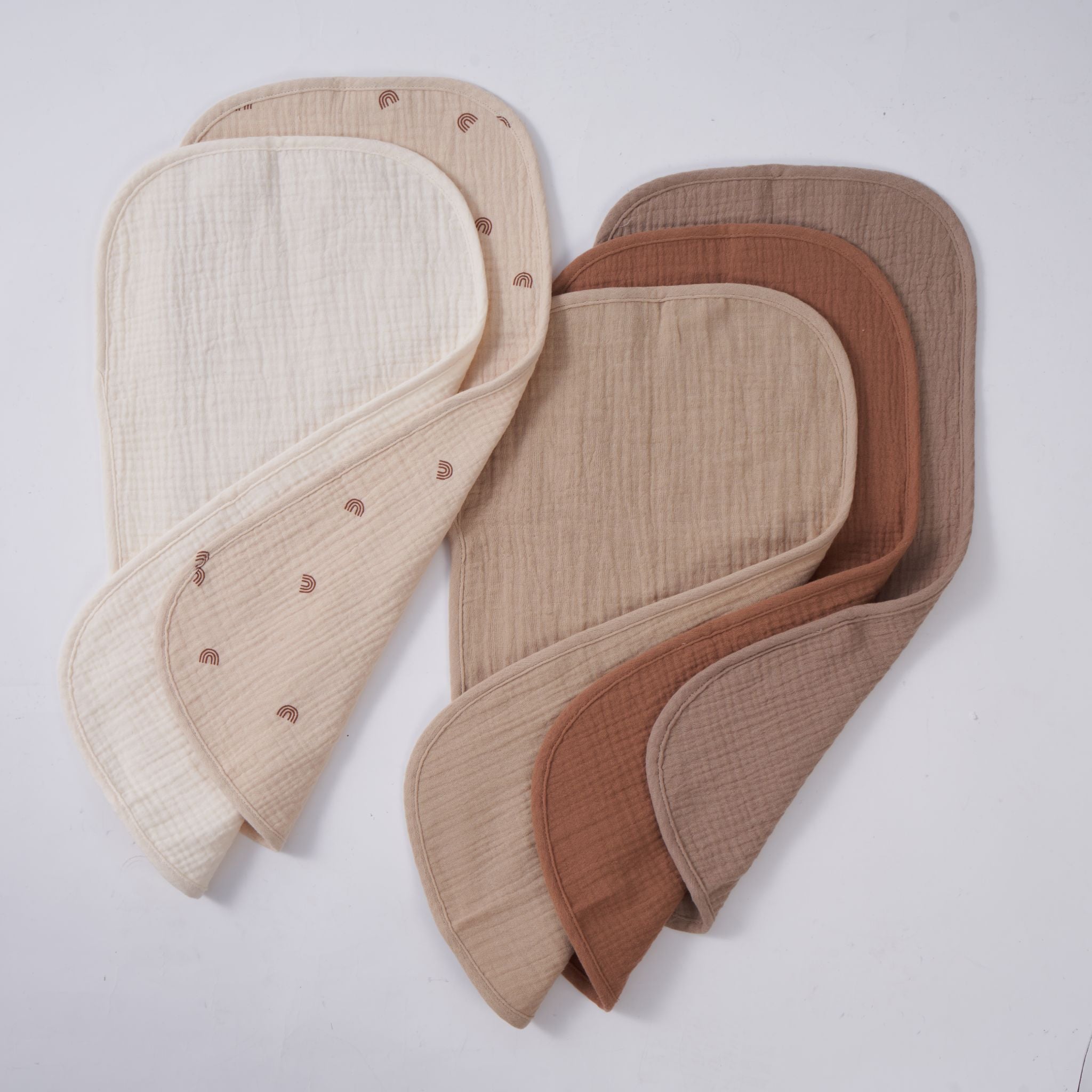 Folded organic muslin burp cloths in dusty dune neutral tones, pack of five