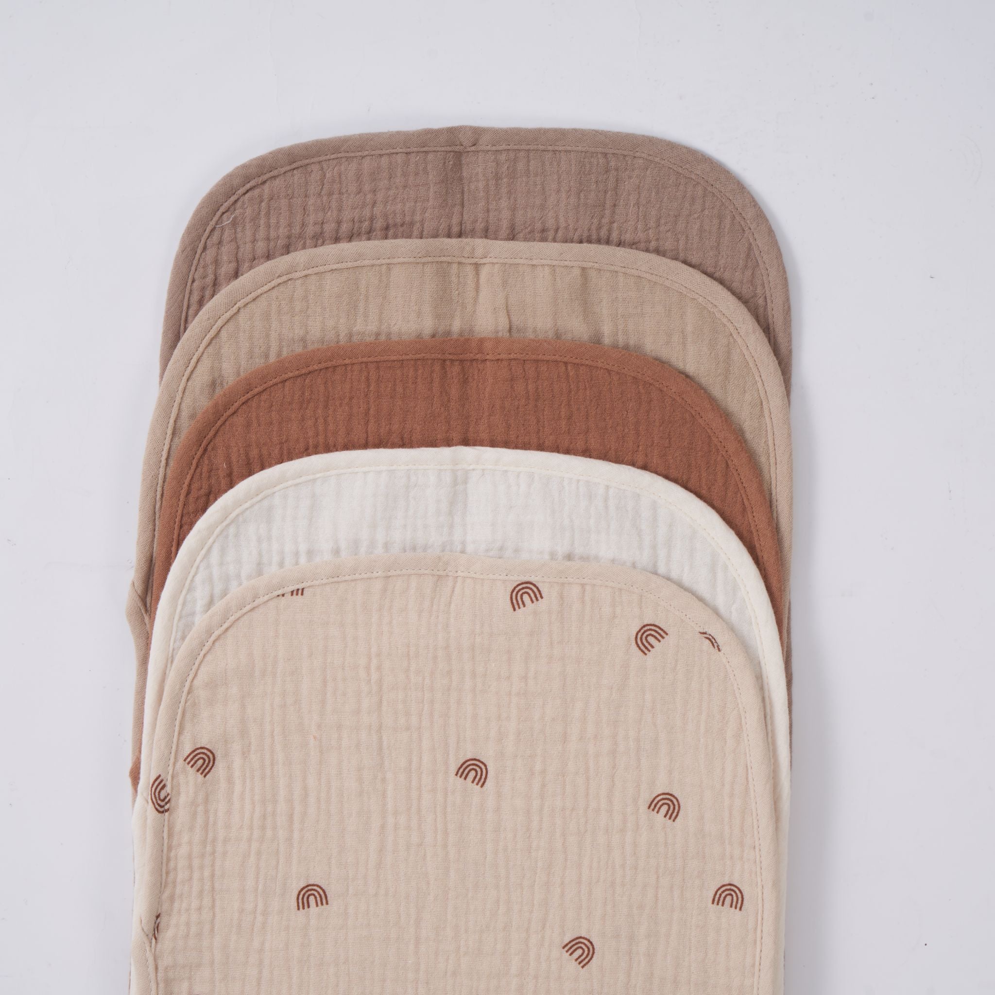 Soft organic muslin burp cloth in dusty dune tone displayed on baby.