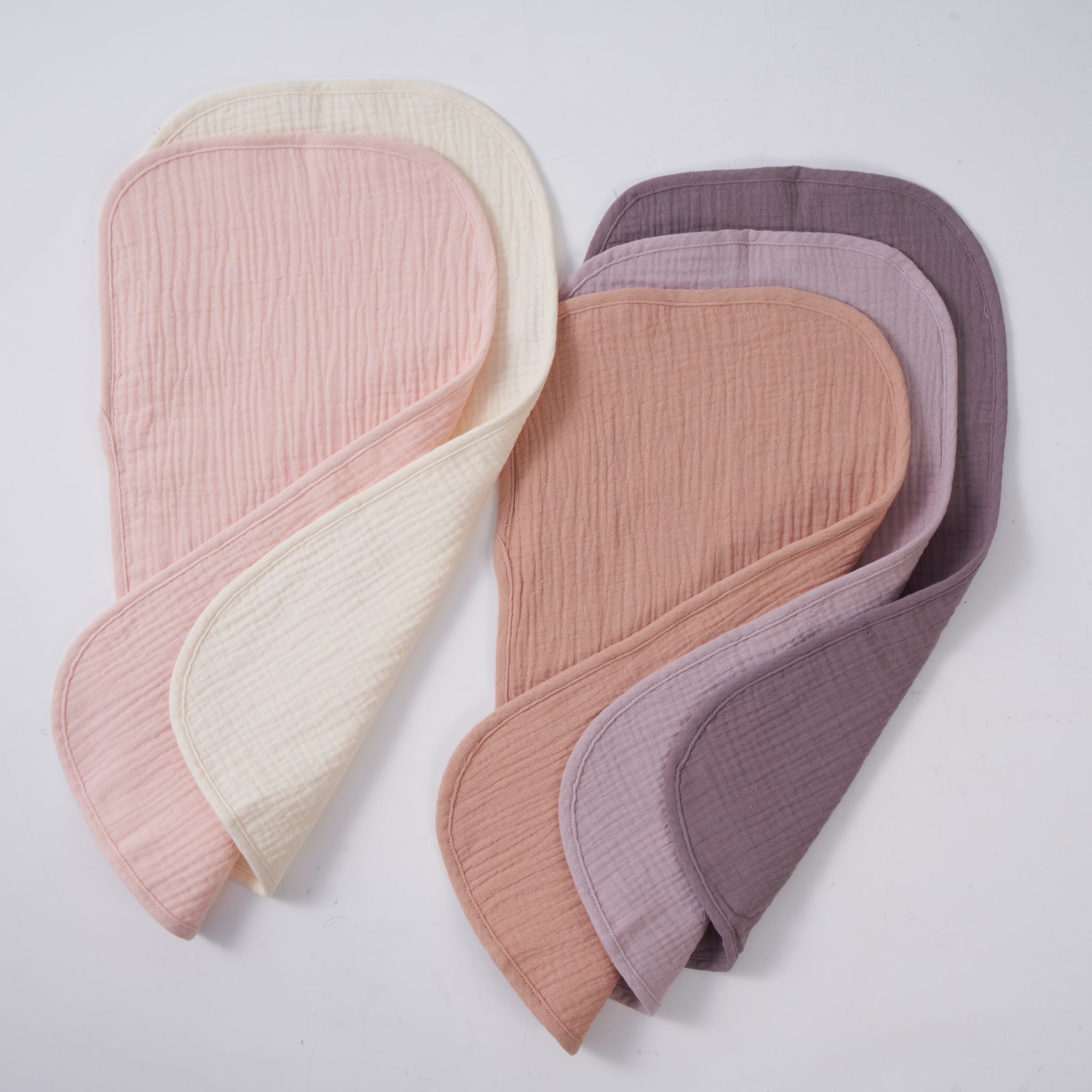 Lavender blush organic muslin burp cloths folded and stacked in a set