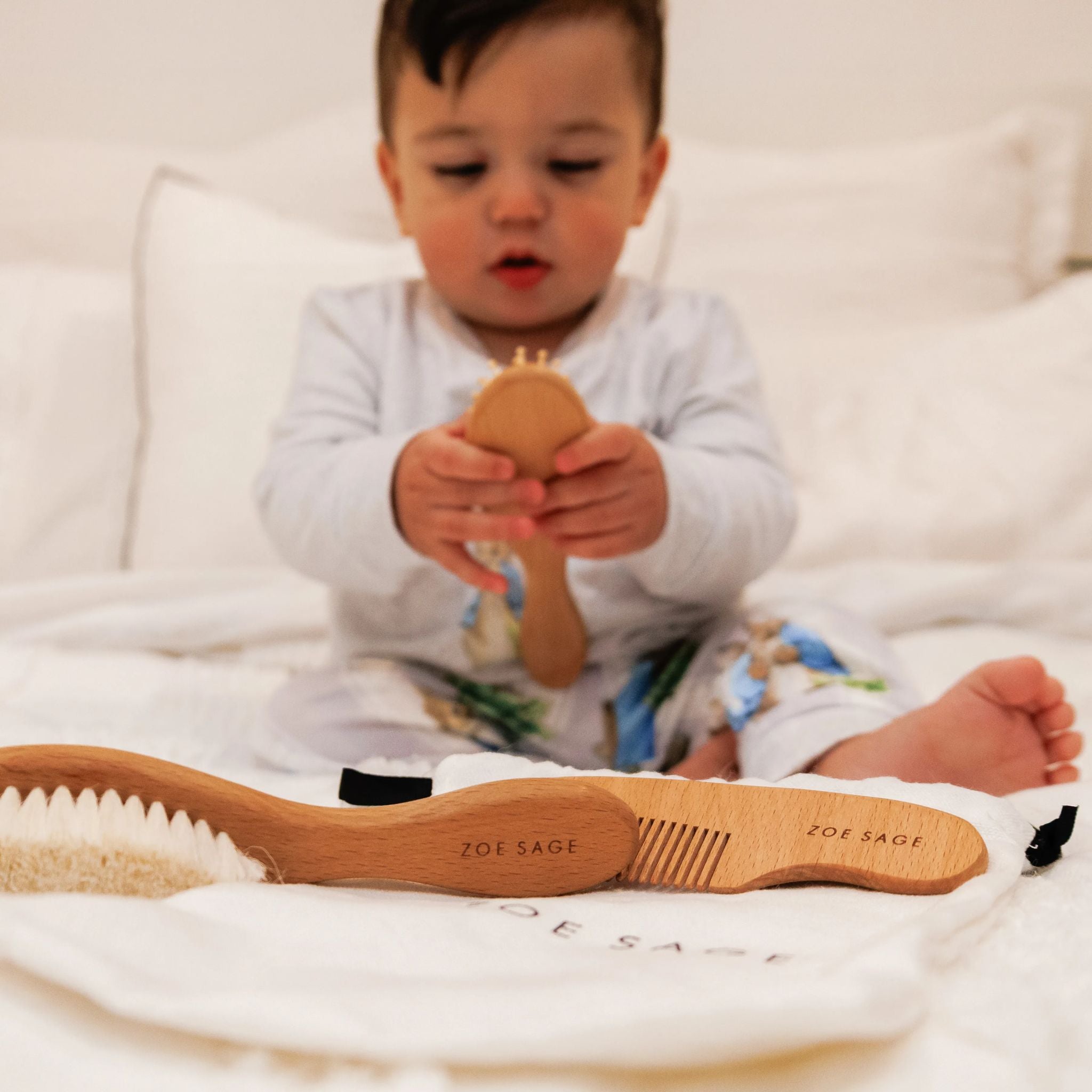 Natural wooden baby brush and comb set in neutral tones displayed in packaging.