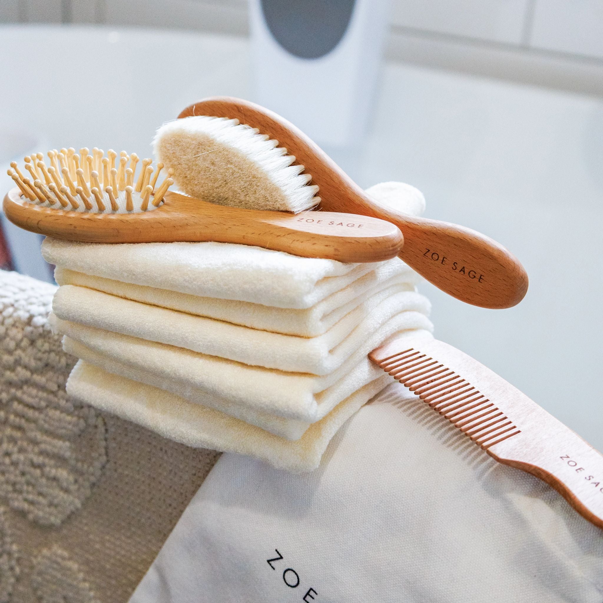 Three piece natural wood baby brush and comb set displayed together