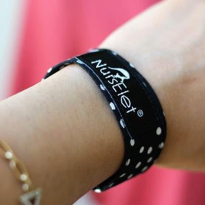 Monochrome dots nursing bracelet worn on wrist during breastfeeding